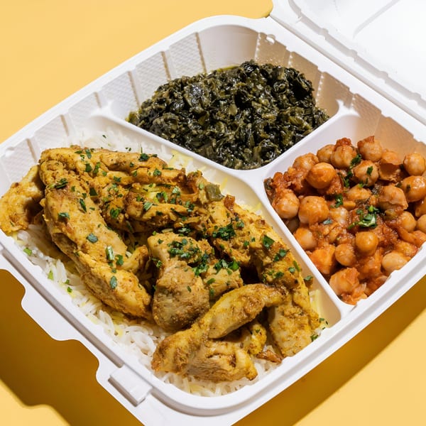 Sheesh Grill's middle-eastern meal with chicken, rice, spinach, and chickpeas in a takeout container.