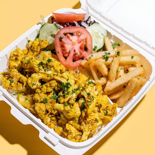 Sheesh Grill's middle-eastern cauliflower and fries with a side salad in a white takeout container.