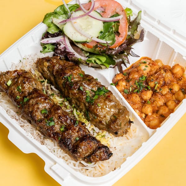 Sheesh Grill's Middle-Eastern platter with two grilled kebabs, rice, chickpea stew, and a fresh salad.