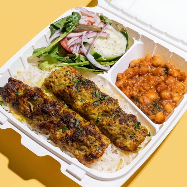 Sheesh Grill's middle-eastern takeout meal with two kebabs, rice, chickpea stew, and a side salad.